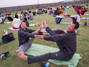 みんなでペアワーク(左:三宅)。こんな楽しいヨガもあります。